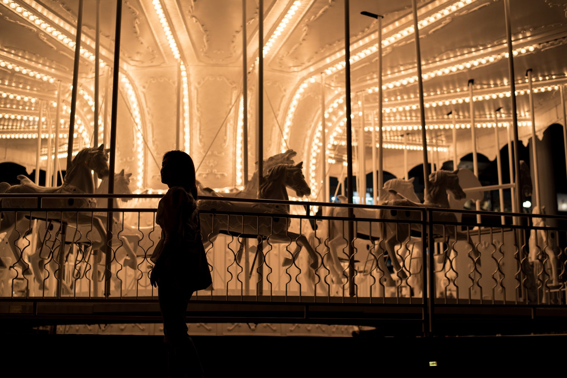 girl standing near carousel