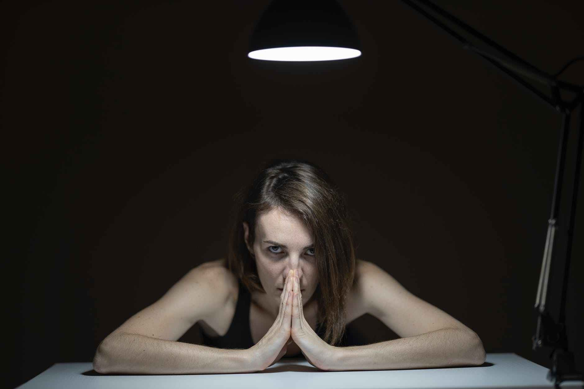 woman wearing black tank top leaning on table