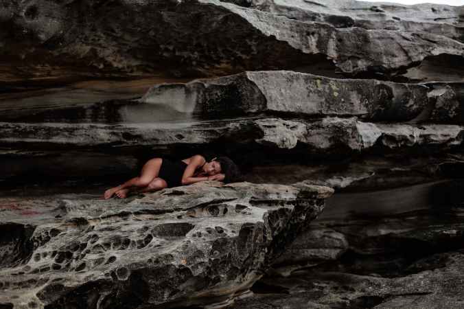woman lying on rock